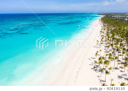 Bounty and pristine sandy shore with coconut palm trees, caribbean sea washes tropical coast. Arenda Gorda beach. Dominican Republic. Aerial view 92619110