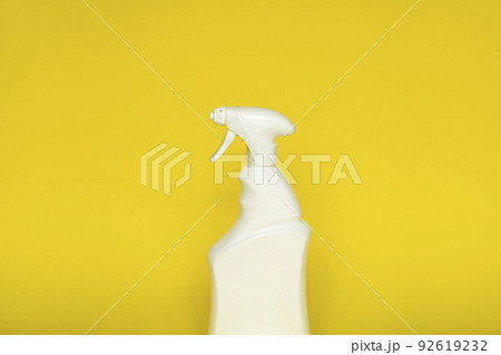 White plastic spray bottle for liquid cleaning products isolated on yellow background. Packaging mockup bottle with sprayer. 92619232