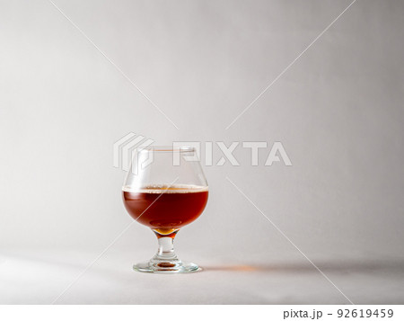 グラスに注がれた褐色のベルギースタイルのビール 92619459