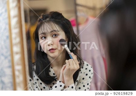 鏡に向かってメイクをする若い女性 92619829