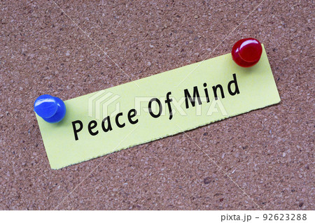 Peace of mind words on stick note and pinned to a cork notice board. 92623288
