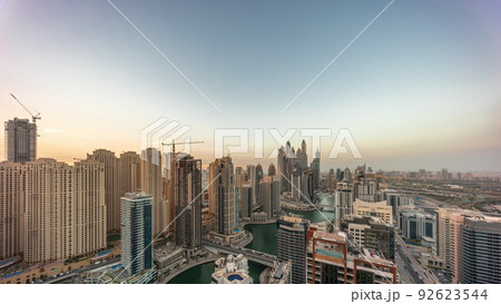 View of various skyscrapers in tallest recidential block in Dubai Marina aerial day to night timelapse 92623544