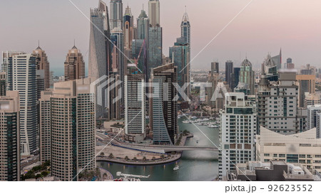 View of various skyscrapers in tallest recidential block in Dubai Marina aerial day to night timelapse 92623552