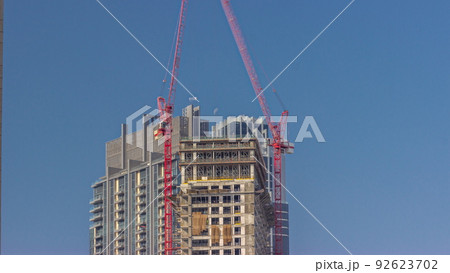 Two cranes working on constraction site works of new skyscraper timelapse 92623702