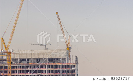 Cranes working on constraction site works of new skyscraper timelapse 92623717