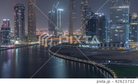 Cityscape of skyscrapers in Dubai Business Bay with water canal aerial night timelapse 92623732