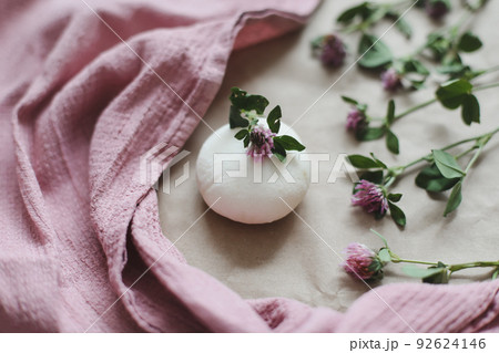 Natural organic soap with flowers and pink towel on craft paper background top view with copyspace 92624146