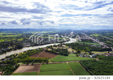 Aerial view of curved large river and village living by the water and agricultural field in countryside at suburban Aerial view of curved large river and village living by the water and agricultural field in countryside at suburban 92625194