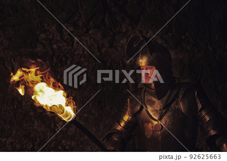 Knight in armour after battle on the black background. 92625663