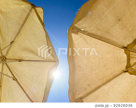 vacation at sea on the beach. high fabric umbrella to protect the body and face from the hot sun, creating artificial shade 92626036
