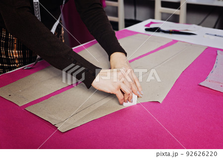Female fashion designer tailor making sewing patterns at workplace in sewing studio. Seamstress working Female fashion designer tailor making sewing patterns at workplace in sewing studio. Seamstress working 92626220