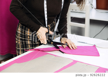 Female fashion designer tailor making sewing patterns at workplace in sewing studio. Seamstress working Female fashion designer tailor making sewing patterns at workplace in sewing studio. Seamstress working 92626222