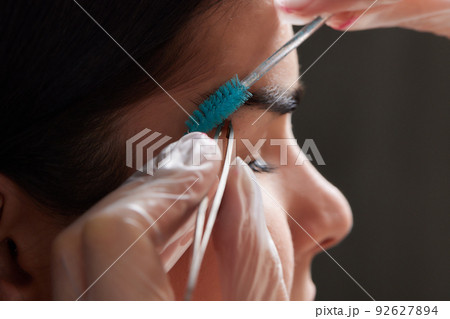 Beautiful young girl got correction of eyebrows in a beauty salon. 92627894