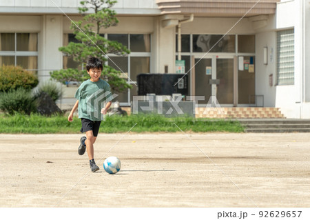 学校でサッカーをしている小学生の男の子 92629657