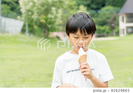 新緑の公園でソフトクリームを食べるアジア人の子供 新緑の公園でソフトクリームを食べるアジア人の子供 92629665