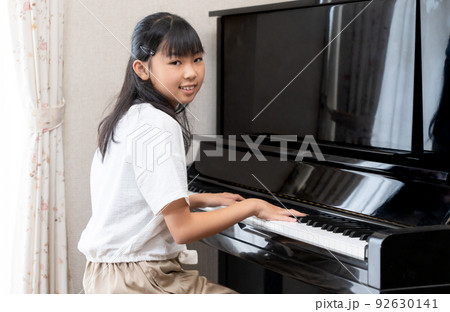 アップライトピアノを弾く日本人の女の子 92630141