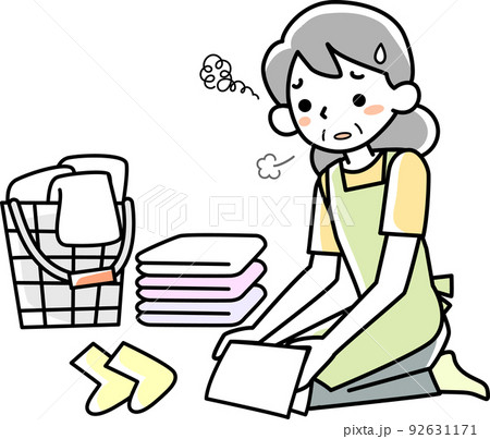 疲れた表情で洗濯物をたたむシニア女性 92631171