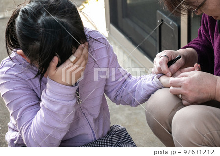 棘を抜いてもらう女の子痛がる子どもと棘を抜く親の写真 92631212