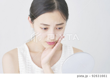 鏡を見て心配する女性 白バック 鏡を見て心配する女性 白バック 92631661