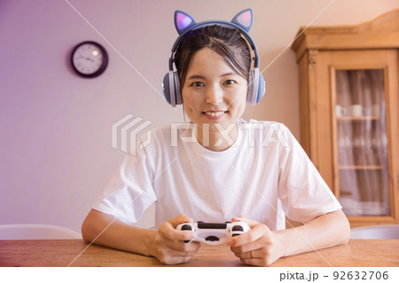 猫耳ヘッドフォンをして家でゲームをする若い女性 猫耳ヘッドフォンをして家でゲームをする若い女性 92632706