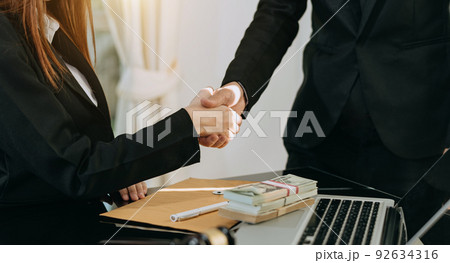 Business handshake closing a deal with blur background of people.. 92634316