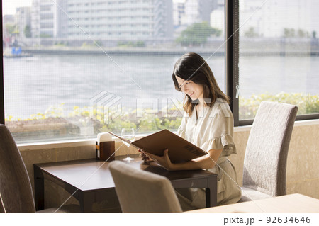 リバーサイドのレストランでメニューを見る若い女性 リバーサイドのレストランでメニューを見る若い女性 92634646