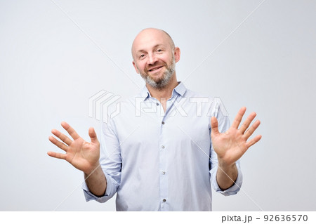 Friendly guy in white casual shirt gesturing Fine, it is enough. Mature european man raising hands and showing palms Friendly guy in white casual shirt gesturing Fine, it is enough. Mature european man raising hands and showing palms 92636570