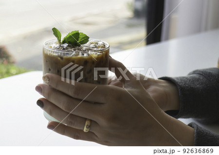 Hand on glass of iced coffee 92636869
