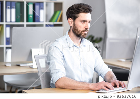 Concentrated and pensive businessman working in the office at the computer, paperwork broker, man looking at the monitor Concentrated and pensive businessman working in the office at the computer, paperwork broker, man looking at the monitor 92637616