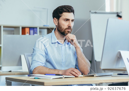 The focused designer works in a modern studio office, the man works during the day at the computer The focused designer works in a modern studio office, the man works during the day at the computer 92637676