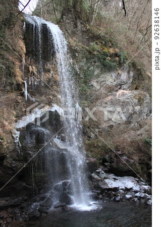 雪の残る夕日の滝 92638146