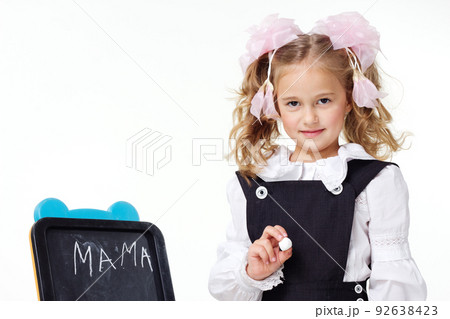 Portrait of a first grader in a school uniform on a white background. Portrait of a first grader in a school uniform on a white background. 92638423