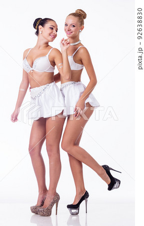 Female duo in studio. Two girls hug at dark background. Sensual models in lingerie. 92638830
