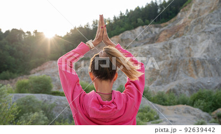 Young woman practicing mindfulness with her palms joined above her head 92639442