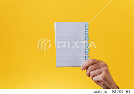 Blank spiral notepad over yellow background Blank spiral notepad over yellow background 92639461
