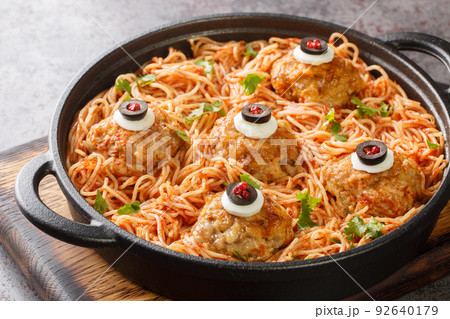 halloween Spaghetti with tomato sauce and meatballs with eyes in a pan on the table close-up. Horizontal halloween Spaghetti with tomato sauce and meatballs with eyes in a pan on the table close-up. Horizontal 92640179