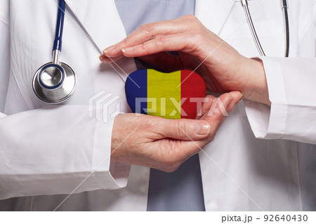Romanian doctor holding heart with flag of Romania background. Healthcare, charity, insurance Romanian doctor holding heart with flag of Romania background. Healthcare, charity, insurance 92640430