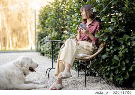 Happy woman with her dog at backyard Happy woman with her dog at backyard 92641730