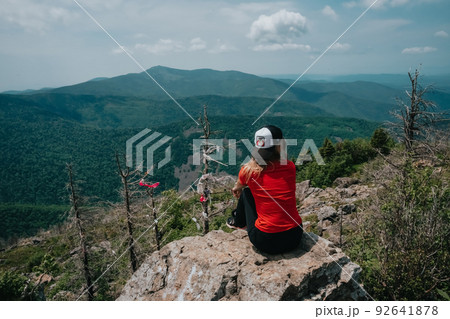 A girl on top of Falaza mountain looks at a beautiful mountain valley. Travel and tourism. Hiking A girl on top of Falaza mountain looks at a beautiful mountain valley. Travel and tourism. Hiking 92641878