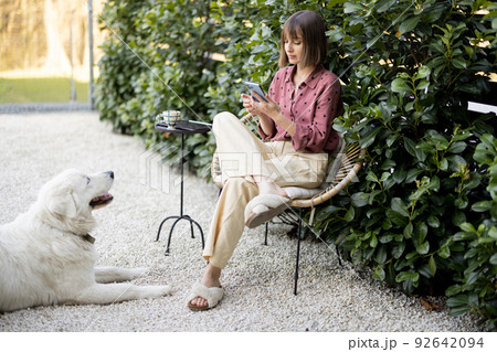 Happy woman with her dog at backyard Happy woman with her dog at backyard 92642094