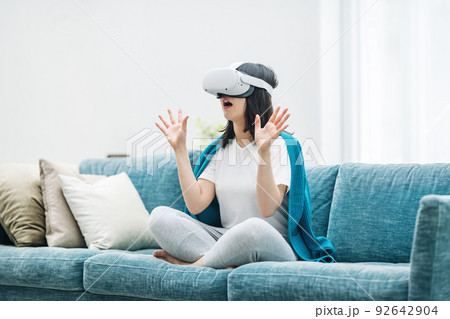 家のリビングでVRを楽しむ女性 92642904