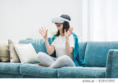 家のリビングでVRを楽しむ女性 家のリビングでVRを楽しむ女性 92642905
