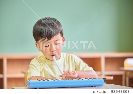 教室で鍵盤ハーモニカを演奏する小学生の男の子 教室で鍵盤ハーモニカを演奏する小学生の男の子 92643803