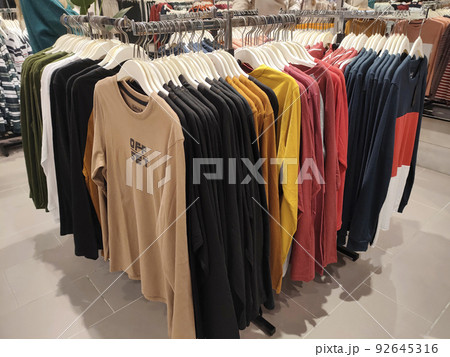 SELANGOR, MALAYSIA -APRIL 4, 2022: Various types of clothes are being sold in the store. Displayed by hanging and folding. Have a price tag for buyer review. Separated by type and brand 92645316