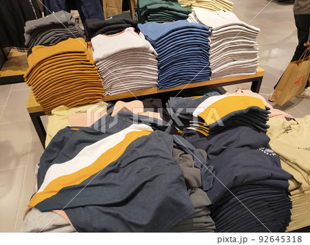 SELANGOR, MALAYSIA -APRIL 4, 2022: Various types of clothes are being sold in the store. Displayed by hanging and folding. Have a price tag for buyer review. Separated by type and brand SELANGOR, MALAYSIA -APRIL 4, 2022: Various types of clothes are being sold in the store. Displayed by hanging and folding. Have a price tag for buyer review. Separated by type and brand 92645318