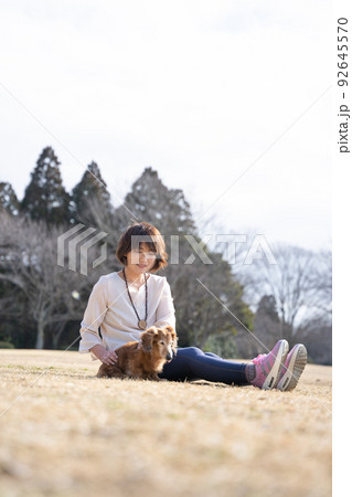 公園で飼い主のアニマルヒーリングに癒される高齢犬 92645570