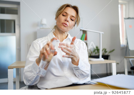Mature woman office worker use sanitizer spray to disinfection her hands 92645877