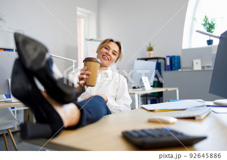 Business woman relaxing during coffee break putting legs on the desk 92645886
