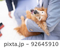 高齢犬を抱っこする男性 92645910