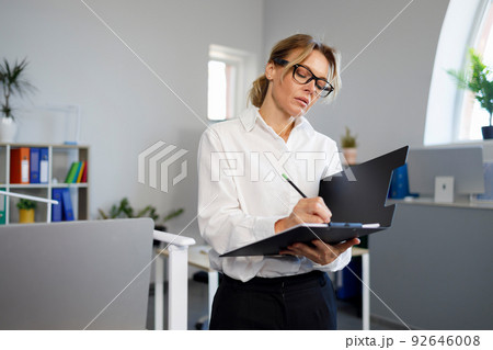 Business woman writing on clipboard Business woman writing on clipboard 92646008